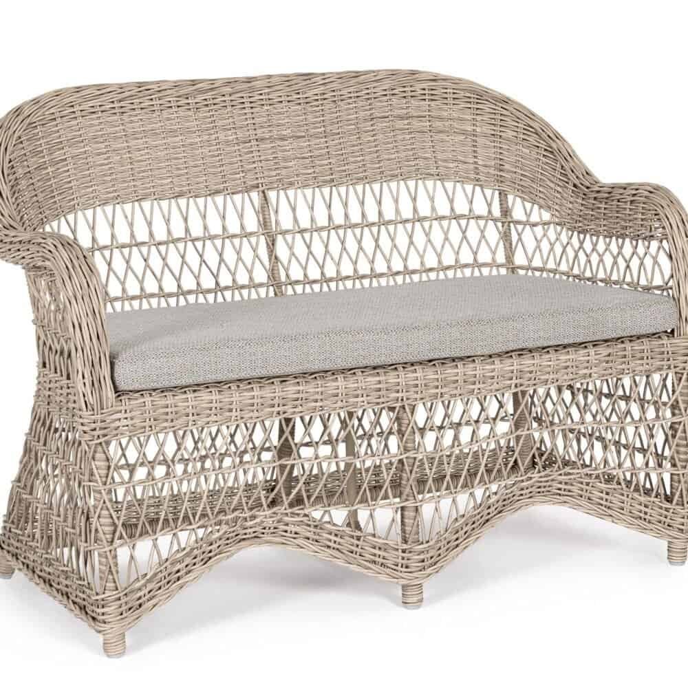 Divano in rattan naturale con cuscino beige, arredamento da esterno elegante e resistente.