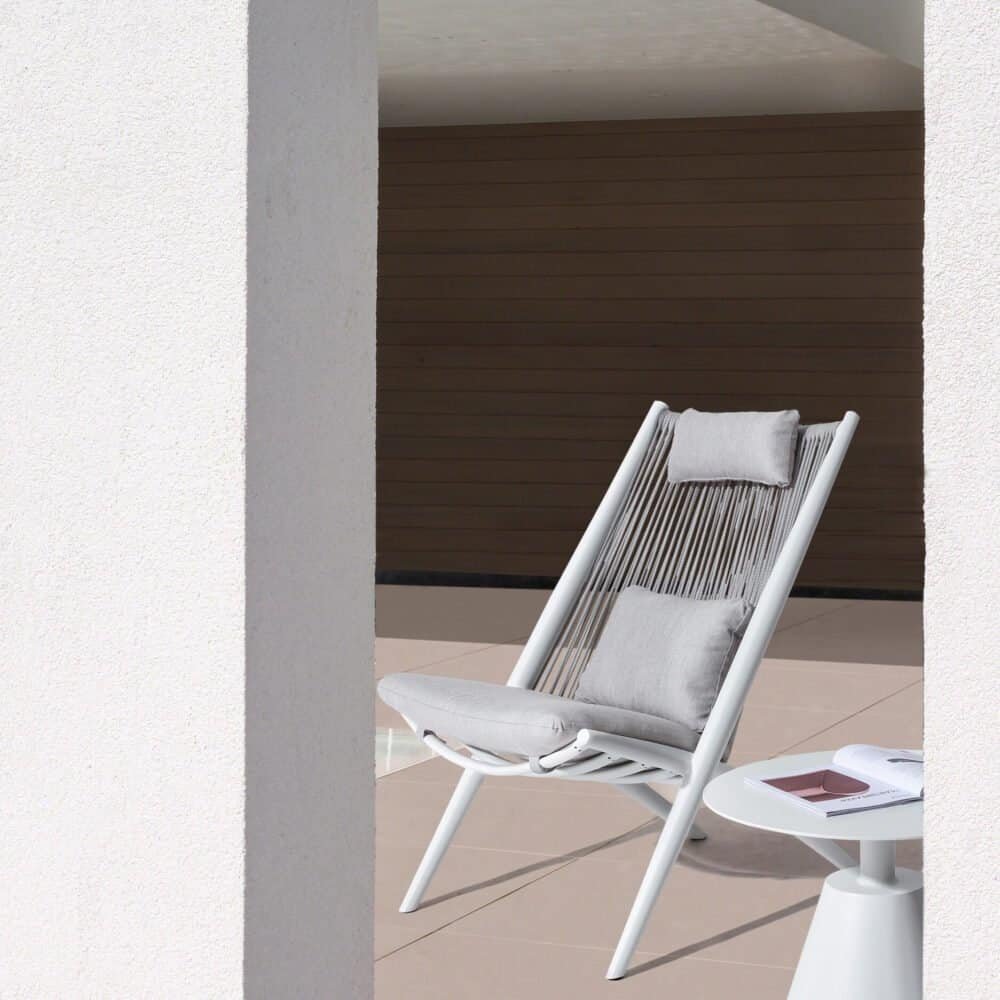 Sedia da esterno moderna con cuscini in tessuto grigio.