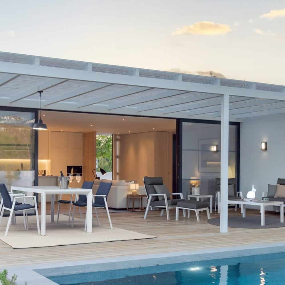 Elenco di zona relax all'aperto con mobili eleganti e piscina.