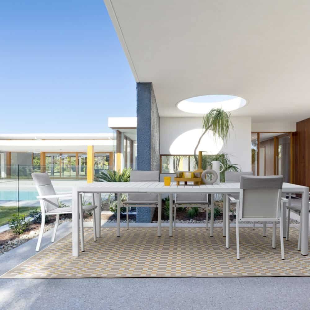 Ampio spazio esterno con veranda, mobili di design e piscina, ideale per relax e convivialità all'aperto.