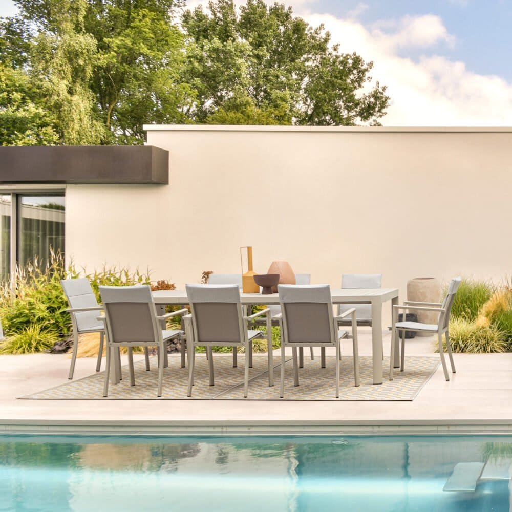 Tavolo da esterno con sedie vicino alla piscina in un cortile moderno e minimalista.