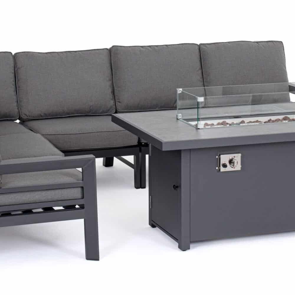 Divano in tessuto grigio con tavolo riscaldato e fiamma finta per esterni raffinati.
