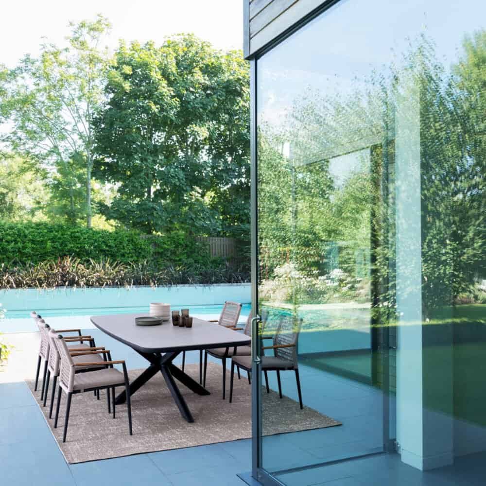 Piscina e area esterna moderna con mobili eleganti, vista sui giardini verdi, ambiente perfetto per il relax all'aperto.