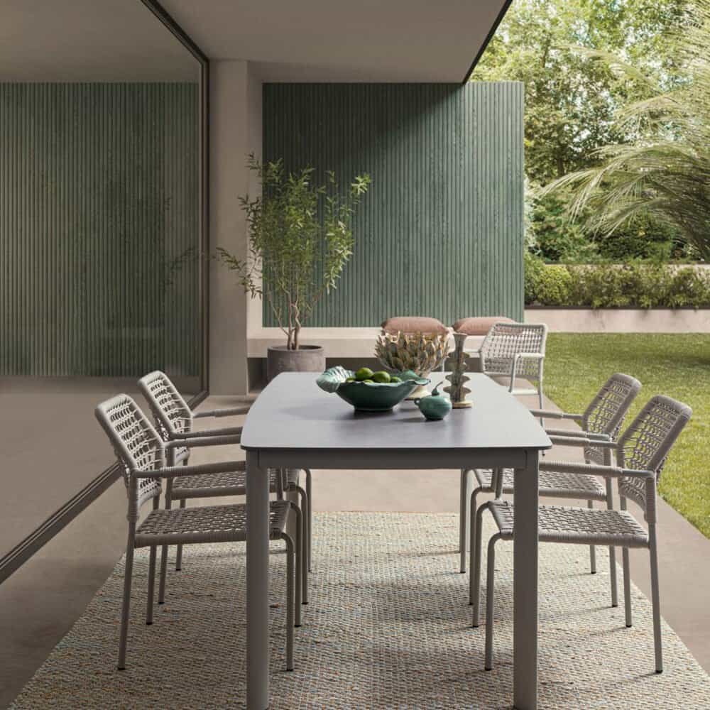 Tavolo e sedie da esterno in stile moderno con design elegante e materiali di alta qualità, perfetti per dining all'aperto.