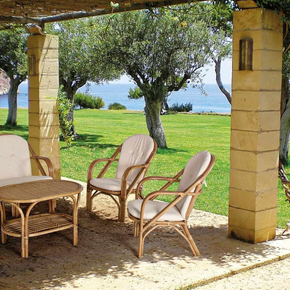 Relaxing outdoor seating with sea view in a garden setting, perfect for leisure and dining.