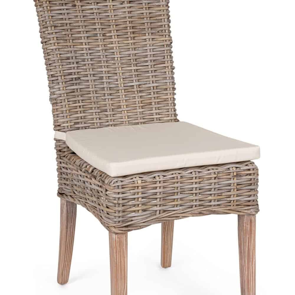 Sedia in rattan con seduta imbottita beige, stile rustico e naturale, ideale per ambienti esterni e tavoli da terrazza.