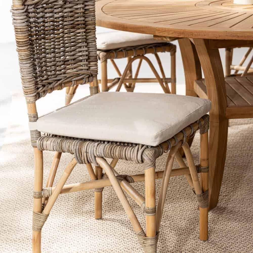 Sedia in rattan con cuscino beige, ideale per arredamento outdoor e indoor, eco-friendly, con design ergonomico.