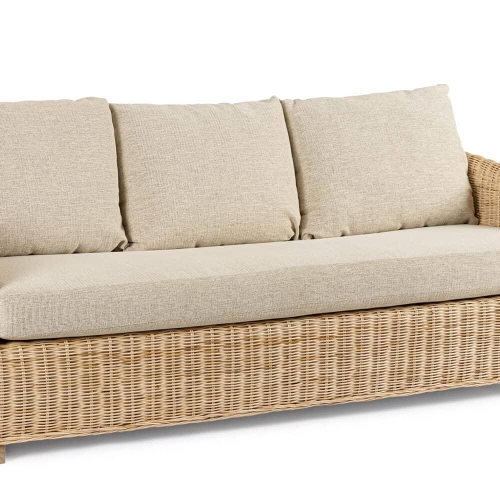 Divano in rattan con rivestimenti in tessuto beige, perfetto per arredi esterni ed interni eleganti e resistenti.