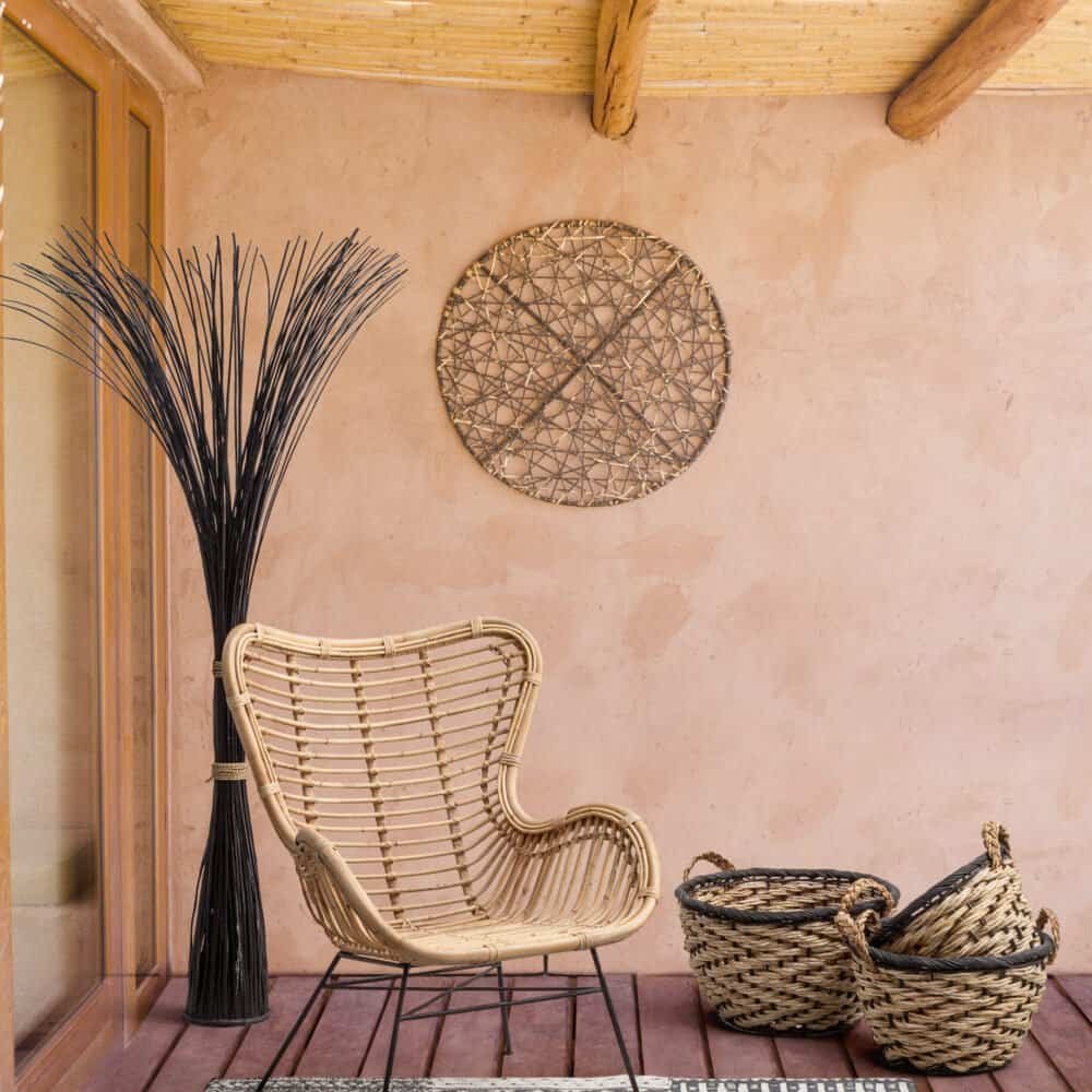 Decorazione boho con poltrona in rattan e cesti in vimini per ambienti da esterno eleganti.