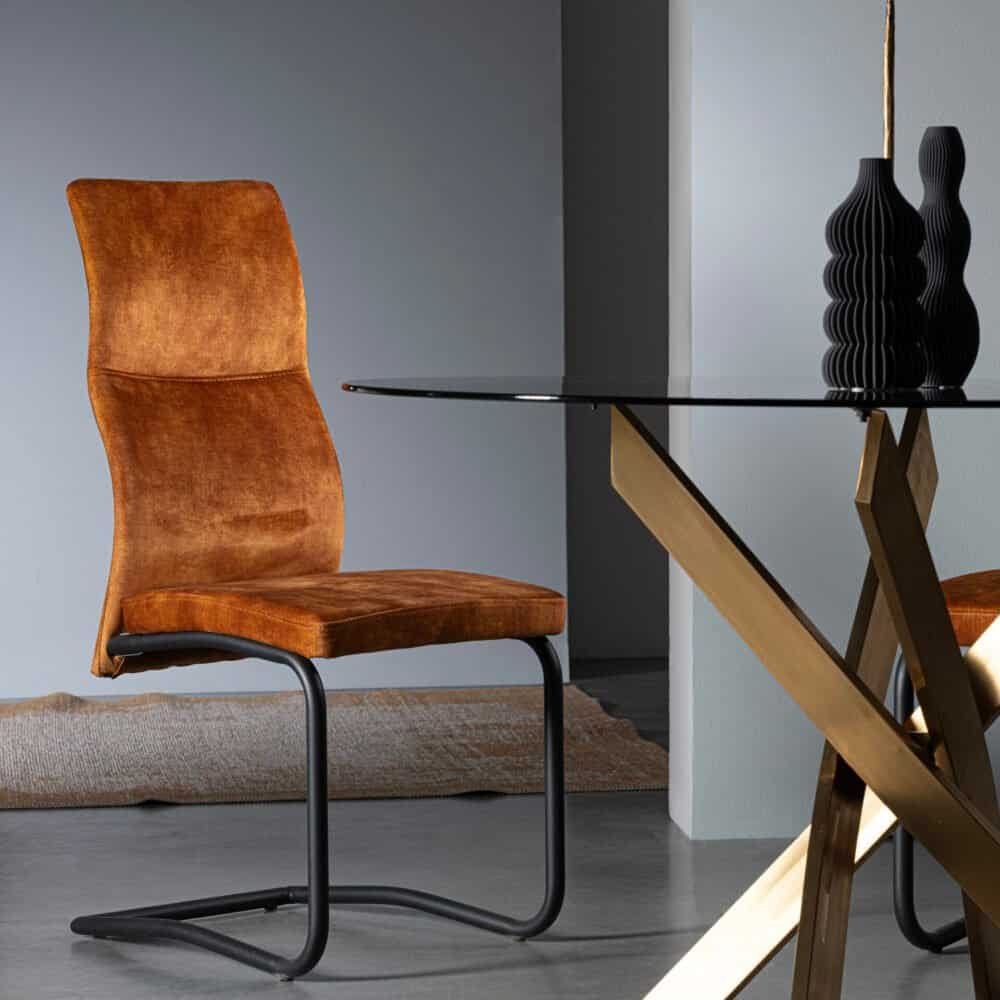 Sedia eleganti in velluto arancione con base in metallo nero, design contemporaneo elegante.