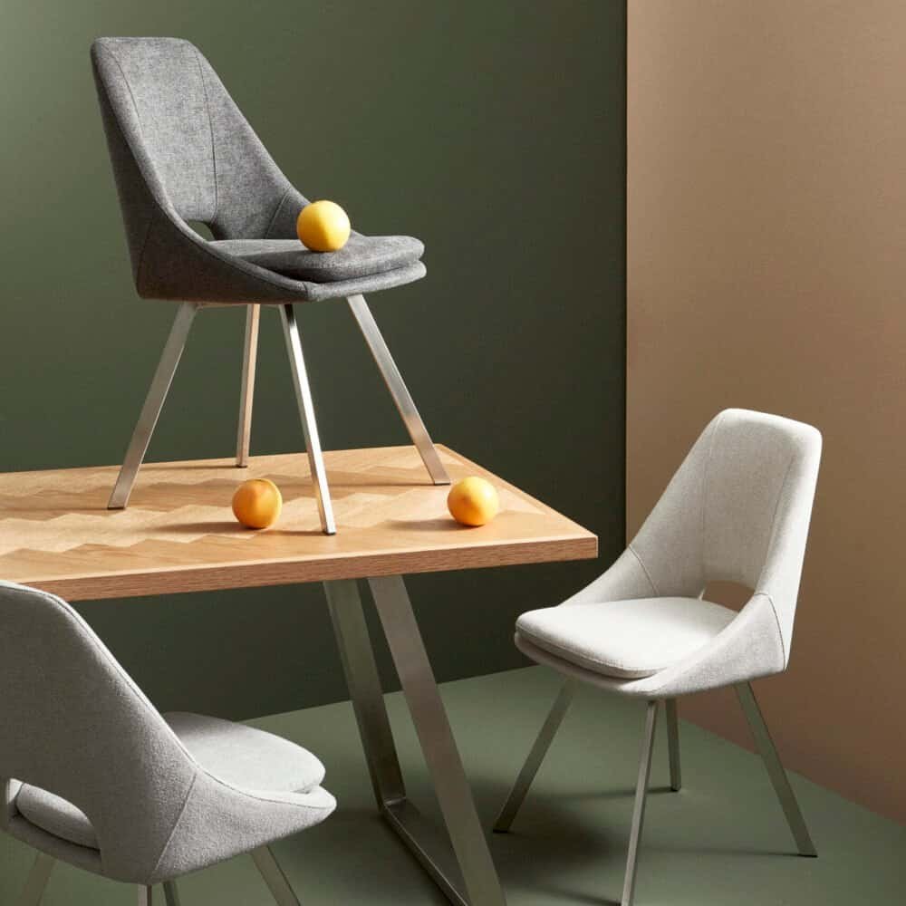 Sedia moderna in tessuto grigio con design innovativo, ideale per soggiorno e zona pranzo.