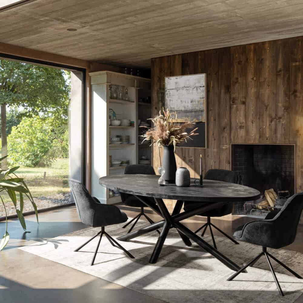 Soggiorno rustico contemporaneo con tavolo in legno scuro, divanetti e dettagli di design.