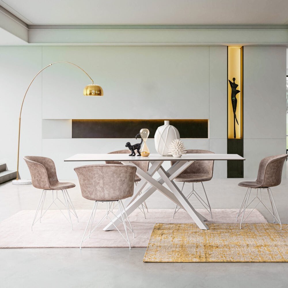 Soggiorno di design con tavolo bianco, sedie velluto rosa, lampada dorata e ornamenti decorativi.