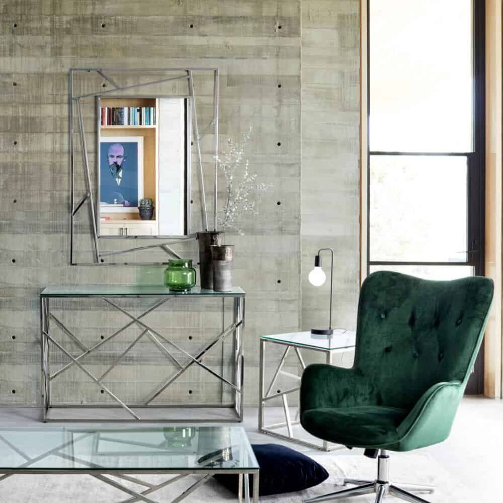 1. Moderno interno living con sedia verde velluto e tavolini in metallo e vetro.