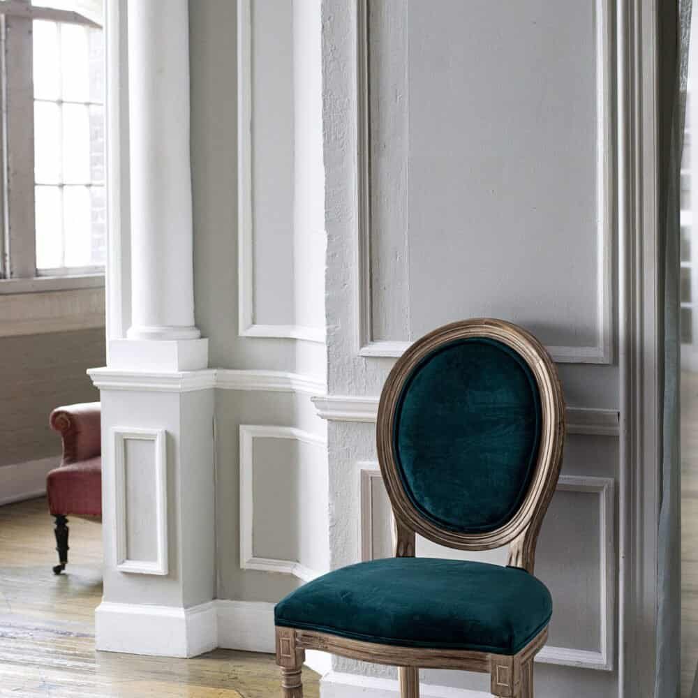 Sedia in stile vintage con rivestimento in velluto blu scuro, arredamento raffinato e di tendenza.