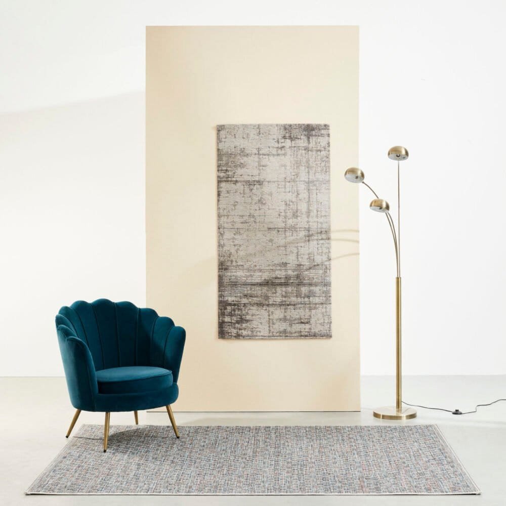 Poltrona blu elegante, lampada moderna e tappeto colorato in un ambiente di design.