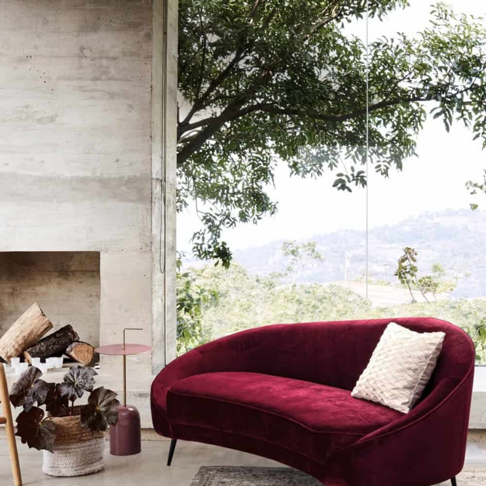 Divano velluto rosso, arredo moderno con vista naturale e atmosfera accogliente.