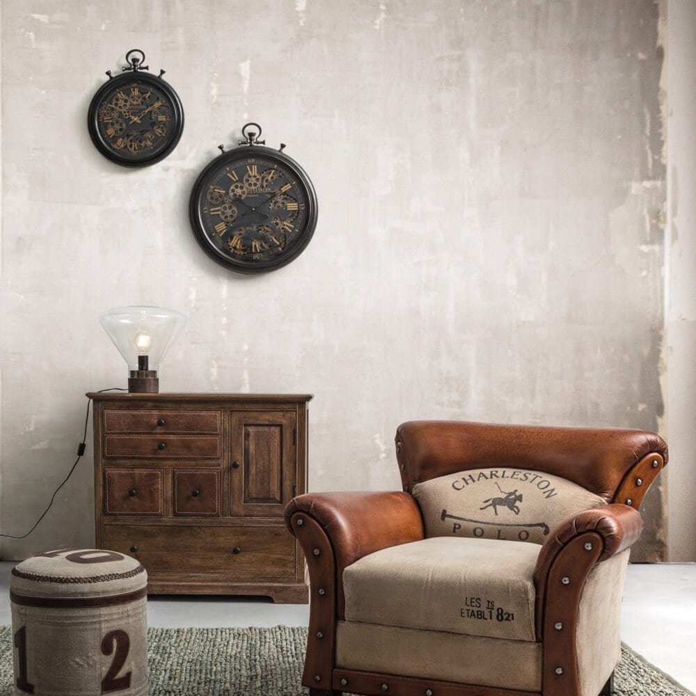 Alt text: Orologi vintage neri con ingranaggi visibili su parete neutra.