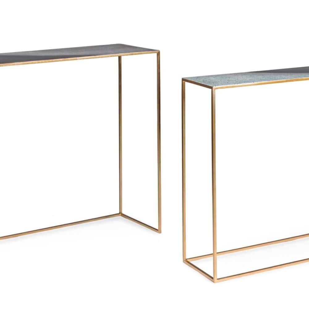 Alt text: Due tavolini eleganti con struttura in metallo dorato e piani in pietra, design minimalista.