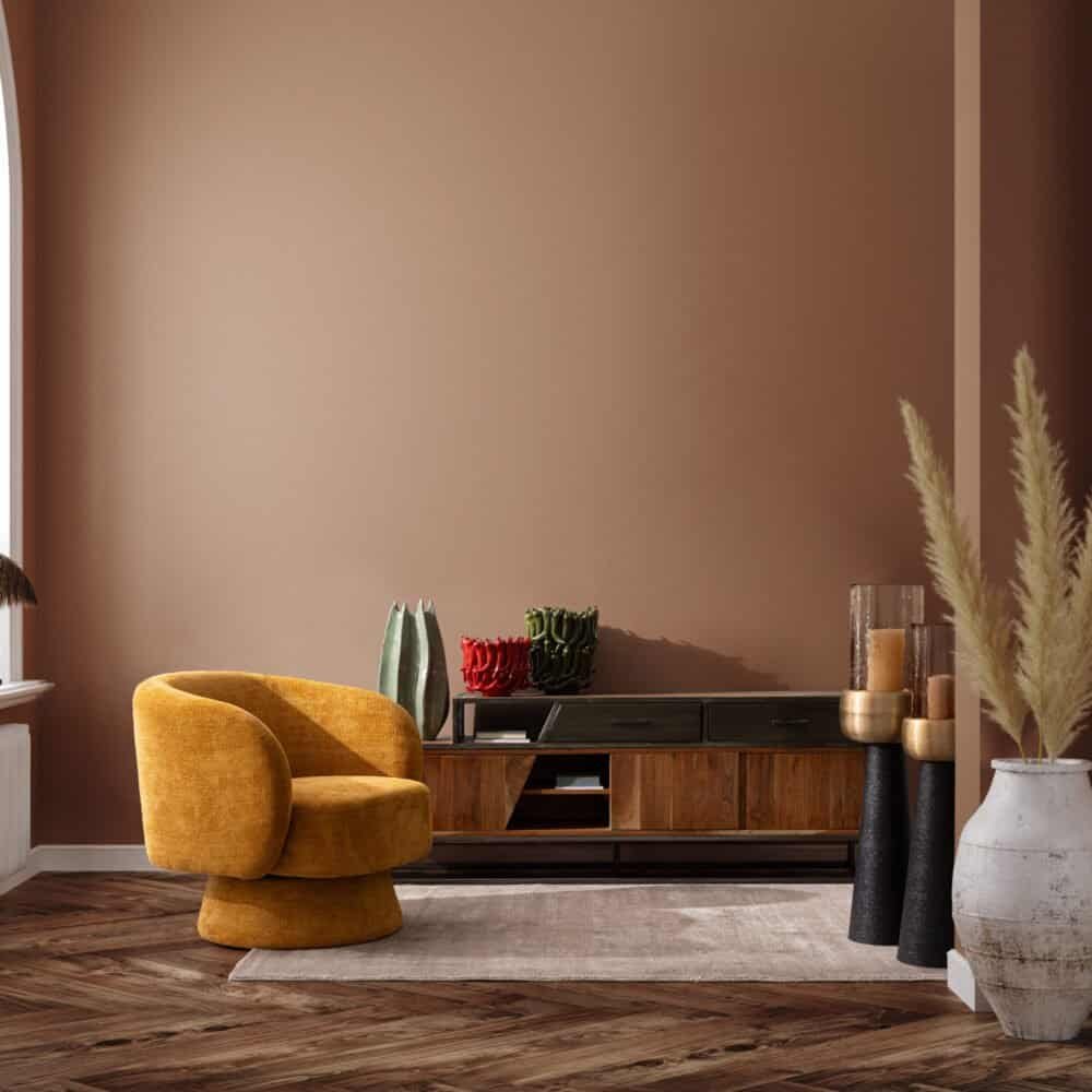 Luminoso salotto con poltrona gialla, mobile in legno scuro e decorazioni artistiche.