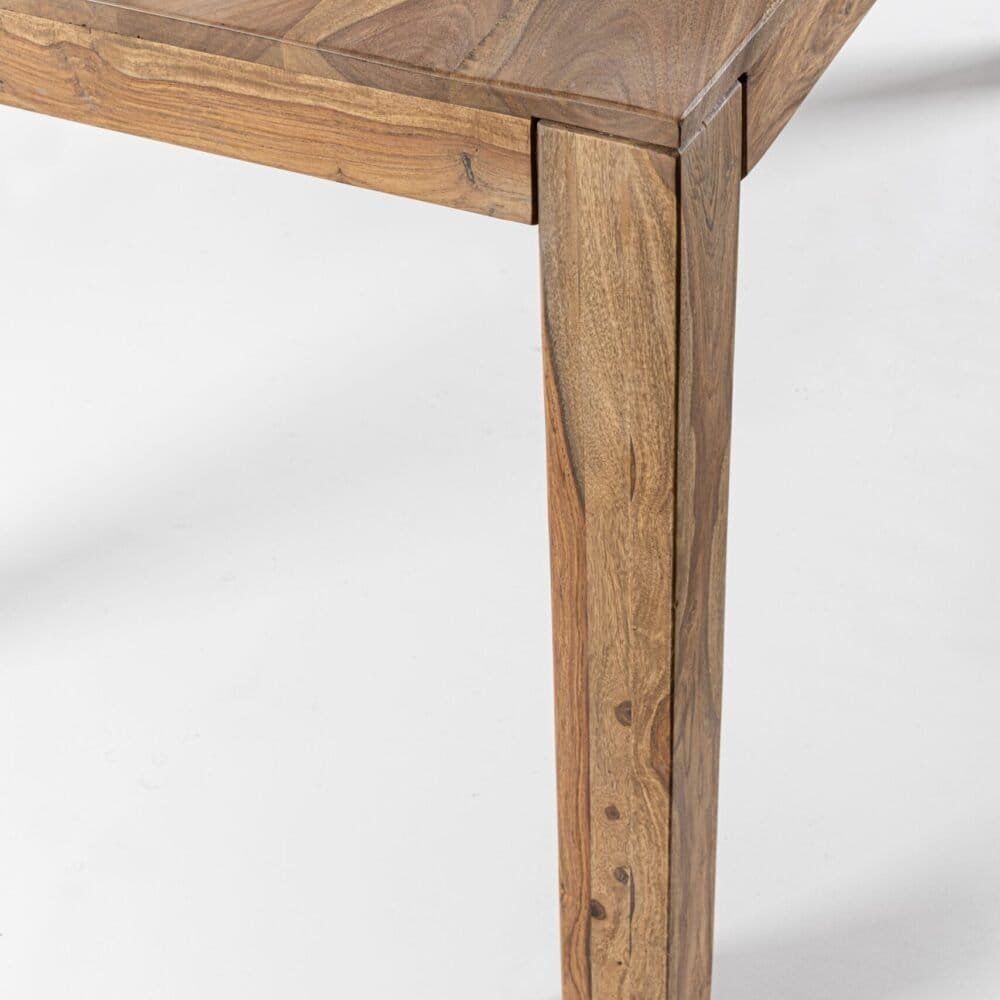 Dettaglio di un tavolo in legno con finitura liscia e dettagli artigianali.