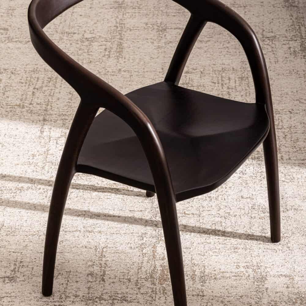 Sedie in legno scuro con seduta imbottita nera, design elegante e moderna.