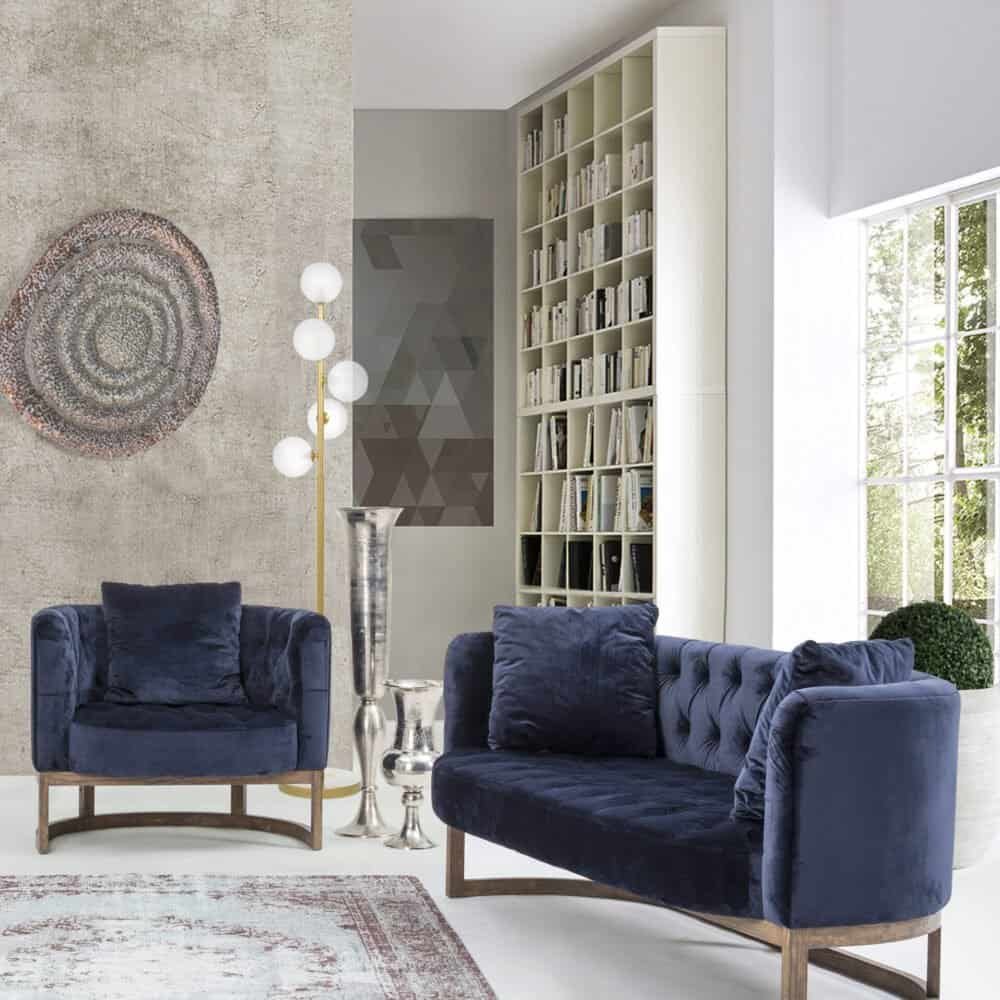 Elegante soggiorno moderno con arredi di design, libreria e divani blu.