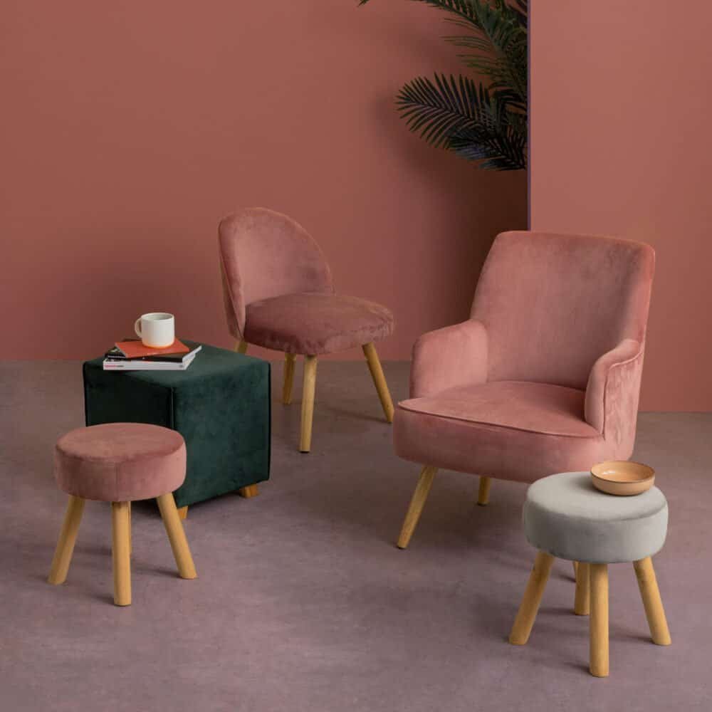 Poltrona rosa e pouf color tutte in morbido velluto rosa, arredi di design per ambientazioni eleganti.