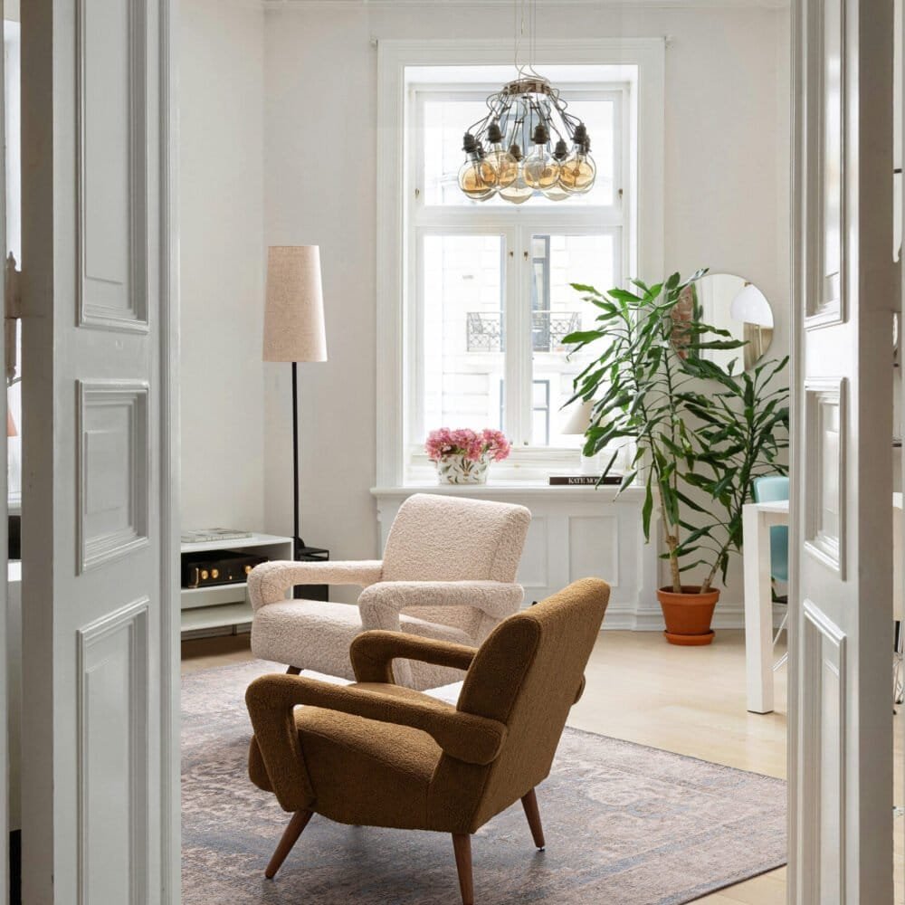 Soggiorno con divani in tessuto, grande finestra e illuminazione moderna, stile accogliente e luminoso.