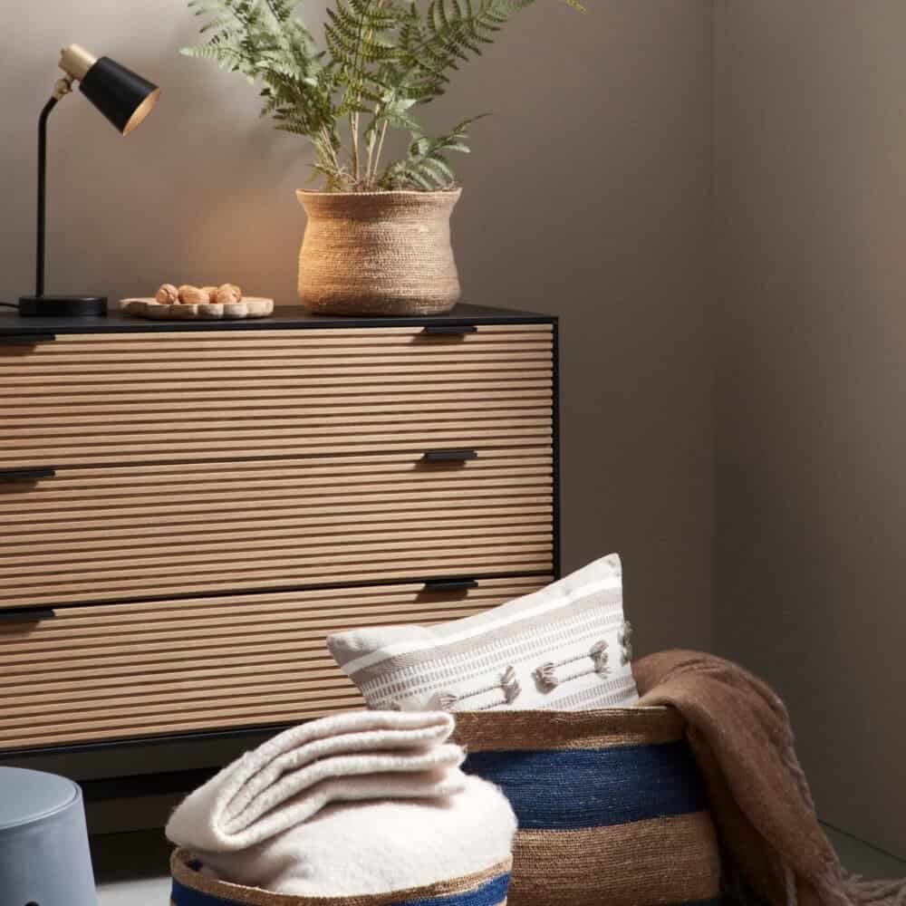 Vaso decorativo in fibra naturale con piante verdi per ambienti interni.