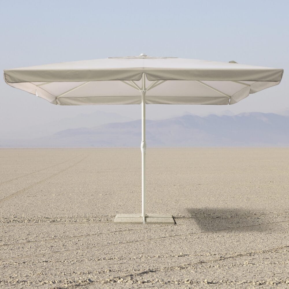 Testo alternativo: Ombrellone bianco su spiaggia deserta con montagne sullo sfondo, ideale per relax estivo.