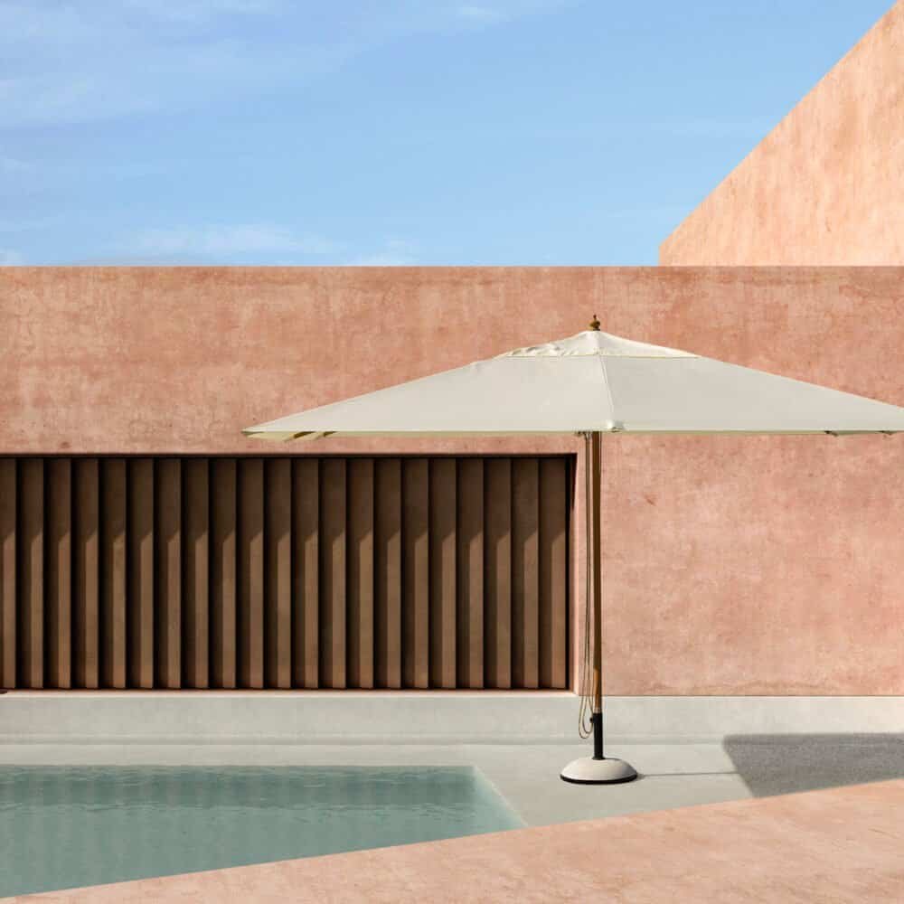 Ombrellone bianco accanto alla piscina in un ambiente minimalista e moderno, ideale per relax e al fresco.