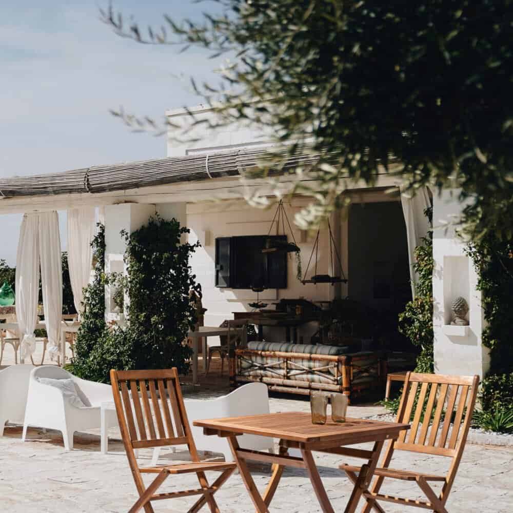 Soggiorno all'aperto con mobili in legno, ambiente estivo e atmosfera rilassante.