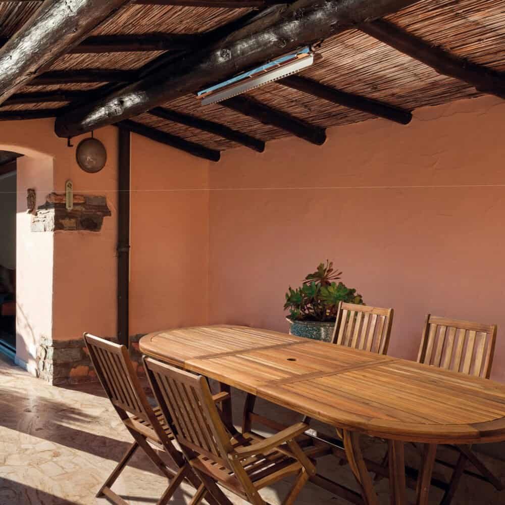 Tavolo esterno in legno in patio all'aperto, perfetto per cene conviviali e momenti di relax.