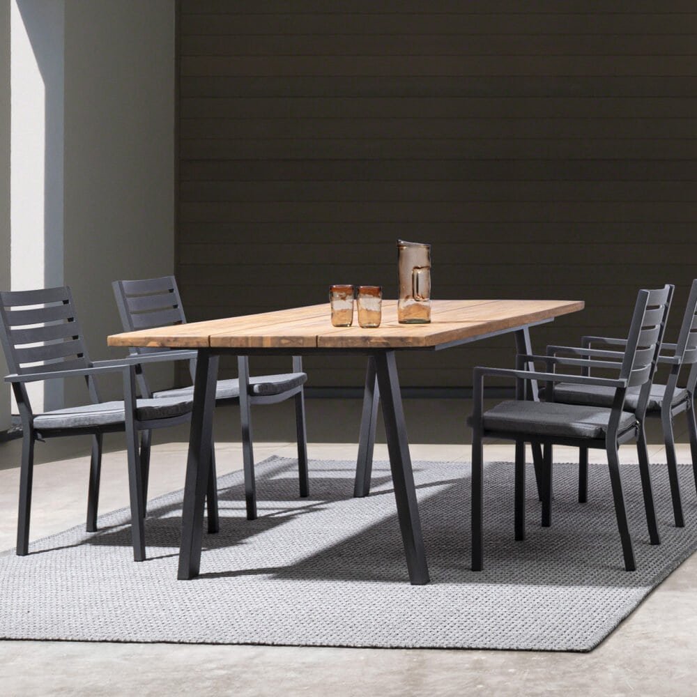 Elegante tavolo da pranzo in legno con sedie nere, ideale per ambienti moderni e raffinati.