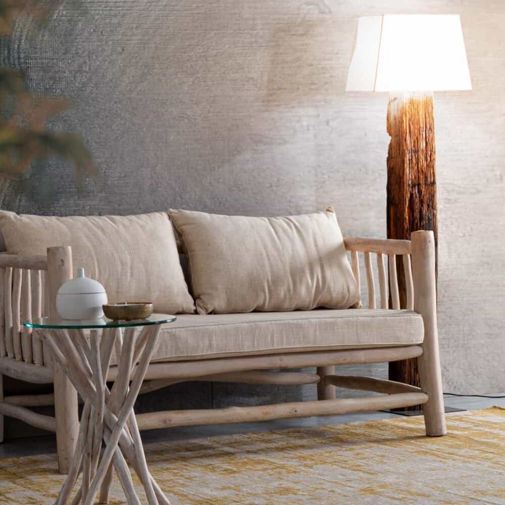 Soggiorno rustico con divano in legno, lampada e decorazioni in stile naturale.