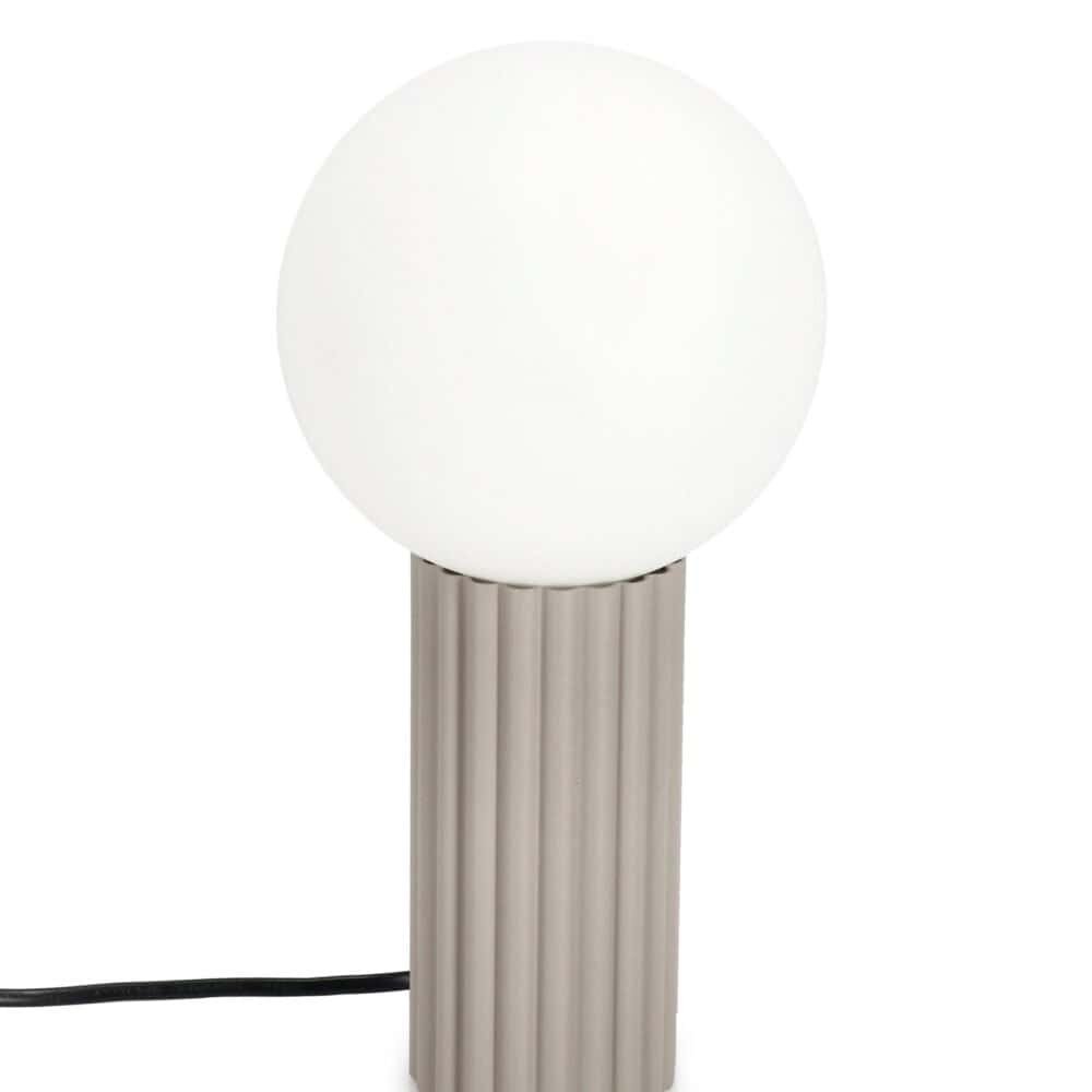 Luce da tavolo con base rigata e sfera di vetro opalino, design elegante e funzionale.