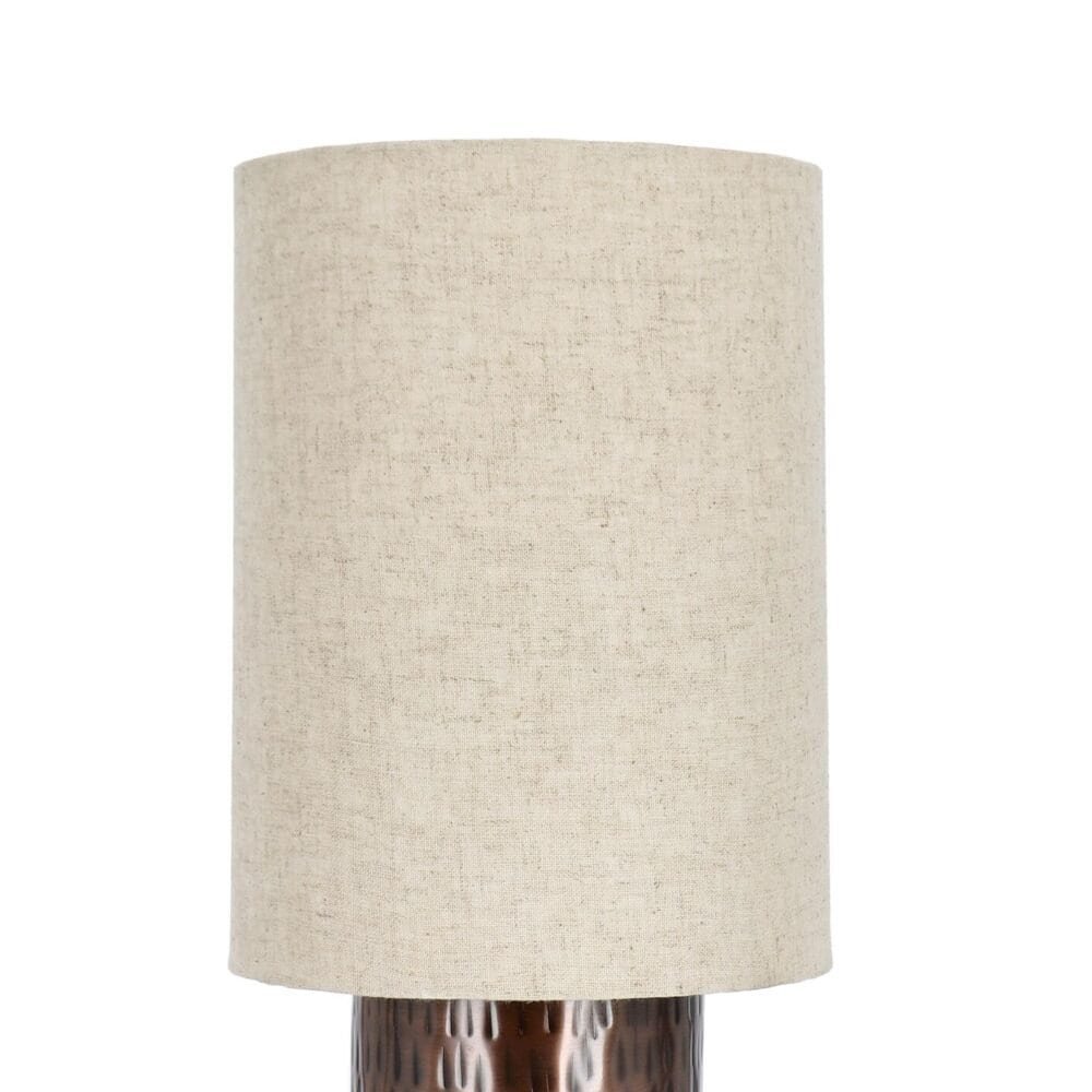 Lampada da tavolo con base in ceramica lavorata e paralume in tessuto naturale.