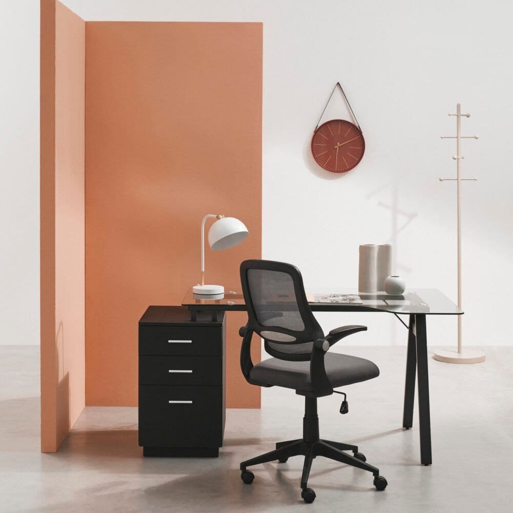 Ampio spazio di lavoro con scrivania moderna e sedia ergonomica in ambiente luminoso.