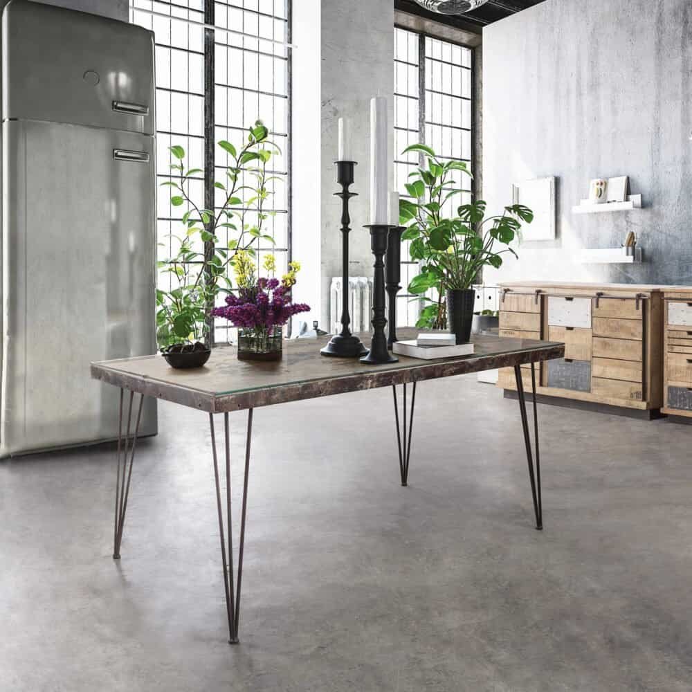 Ampio spazio con mobili industriali, piante verdi e decorazioni eleganti in un ambiente luminoso.