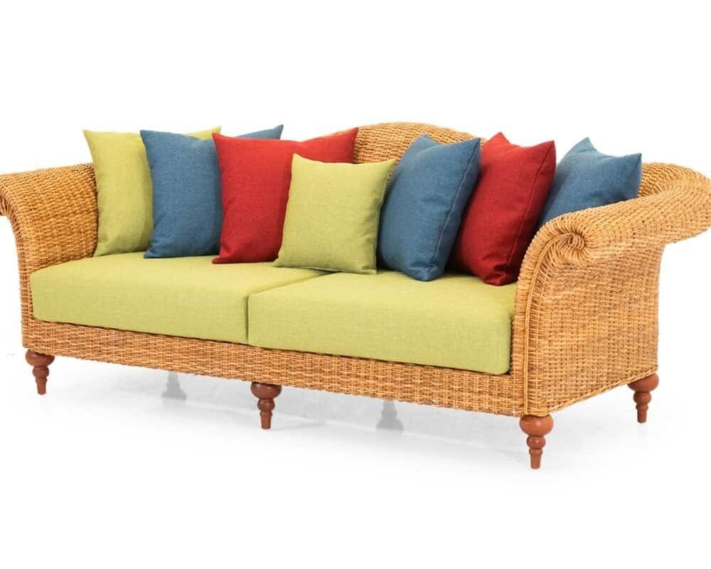 Divano in vimini esterno con cuscini colorati, perfetto per arredo giardino e zona relax all'aperto.