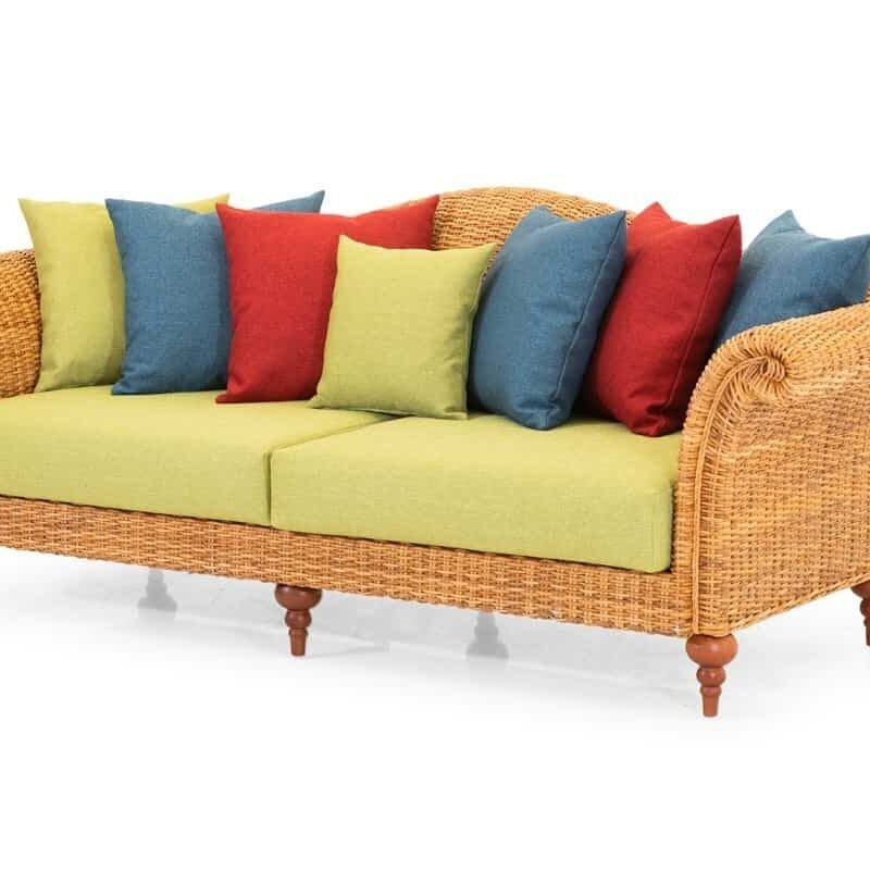 Divano in vimini esterno con cuscini colorati, perfetto per arredo giardino e zona relax all'aperto.