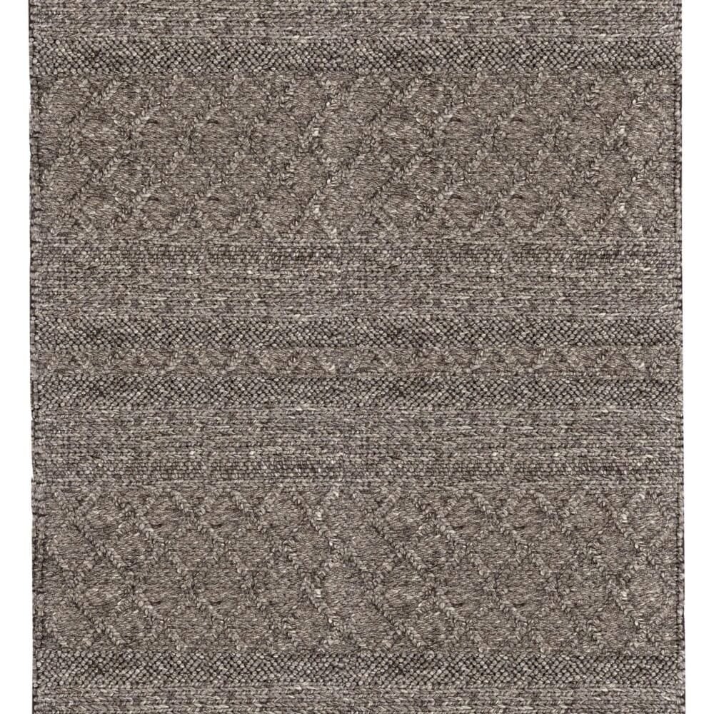 Tappeto naturale con motivi geometrici e frange, perfetto per arredare con stile l'ambiente di casa.