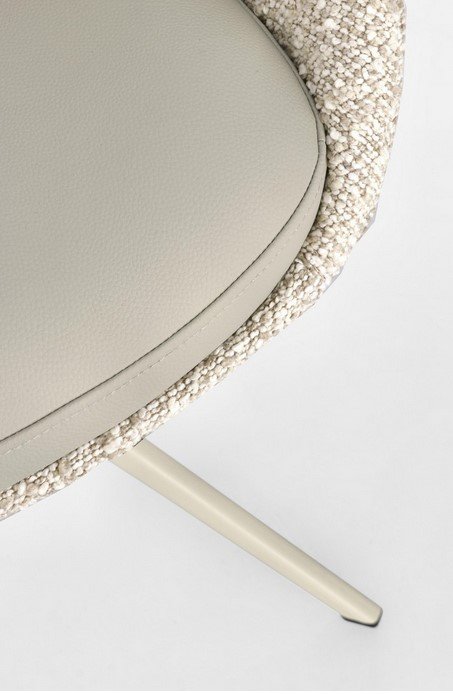 SEDIA AVERIK BEIGE6 - JOLLYGIUNCO Close-up of a beige upholstered chair with a woven textured edge and a pale cream leg visible at the bottom.