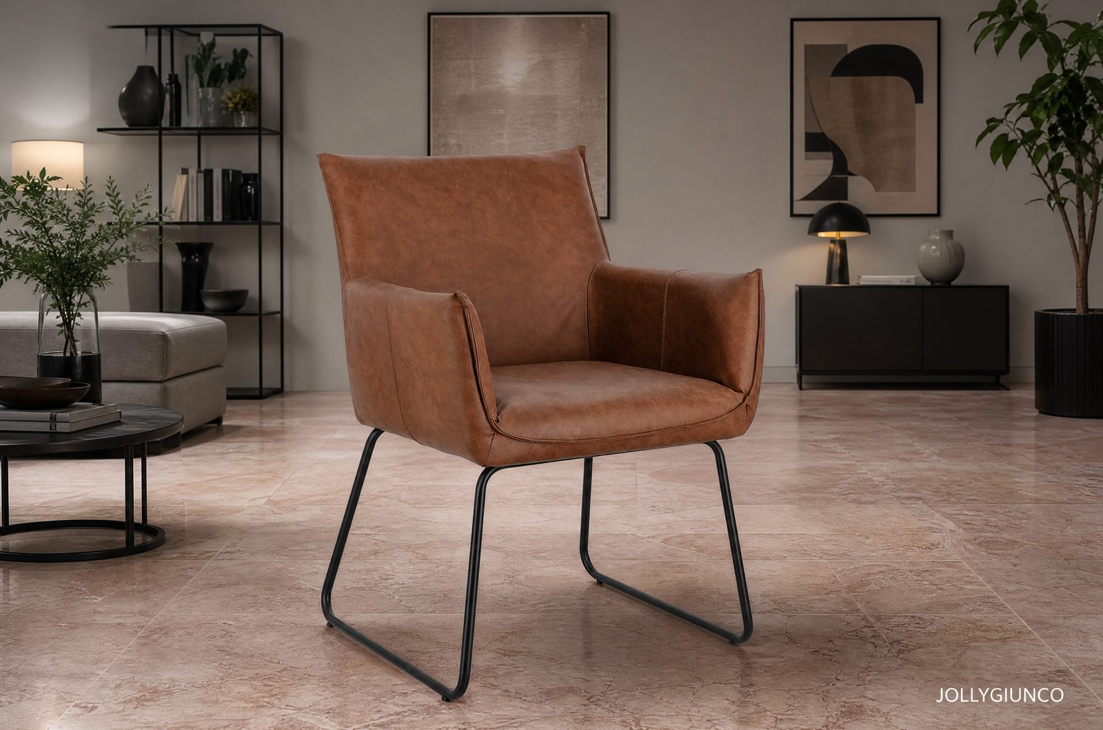 SEDIA C-BR EVELYN COGNAC10 - JOLLYGIUNCO Brown leather lounge chair with metal legs in a modern living room with plants, art on the walls, and a black shelving unit in the background.