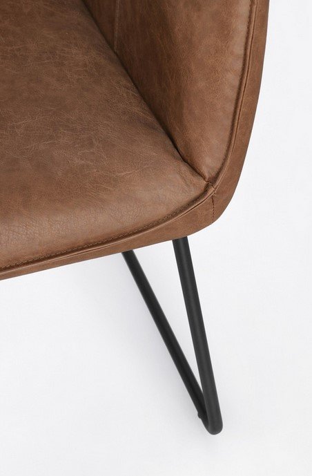 SEDIA C-BR EVELYN COGNAC7 - JOLLYGIUNCO Close-up of a brown leather chair seat corner with black metal legs visible underneath.