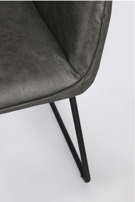 SEDIA C-BR EVELYN DARK7 - JOLLYGIUNCO Close-up of a dark gray leather chair seat corner with black metal legs on a light background.
