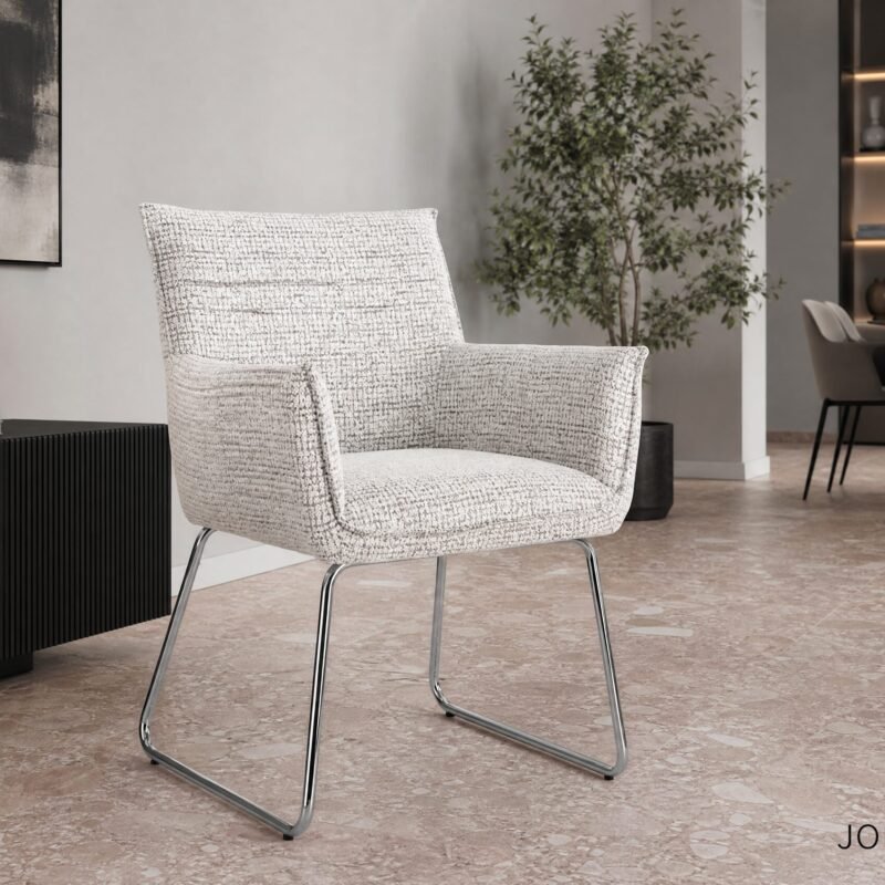 Modern living room with a textured white chair, black ribbed console, abstract wall art, and a tall plant in the background.