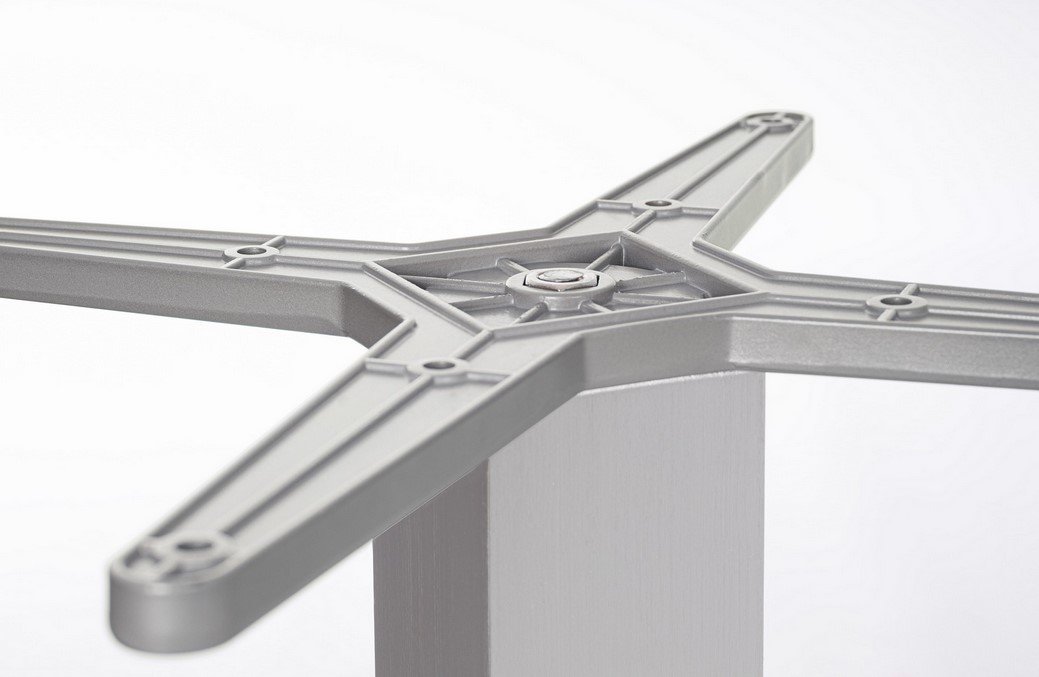BASE TAVOLO VESTA ALLUM H722 - JOLLYGIUNCO Close-up of a gray cross-shaped plastic mounting plate attached to a light gray table leg, showing screw holes at the ends of each arm.