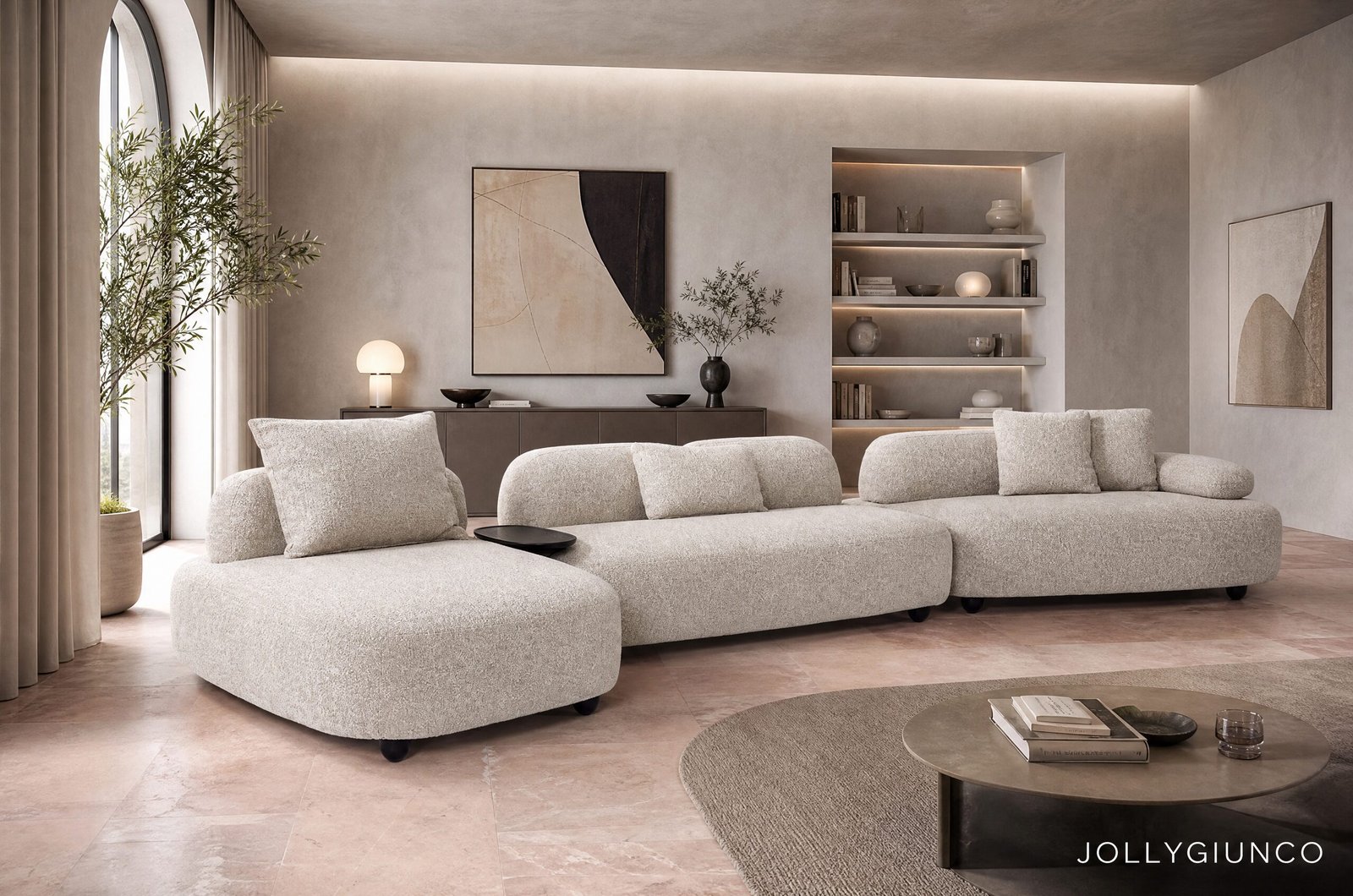 DIVANO 4+1P C-C ISIDE C-PENISOLA10 - JOLLYGIUNCO Neutral living room with a large beige sectional, round coffee table, and built-in lit shelves.